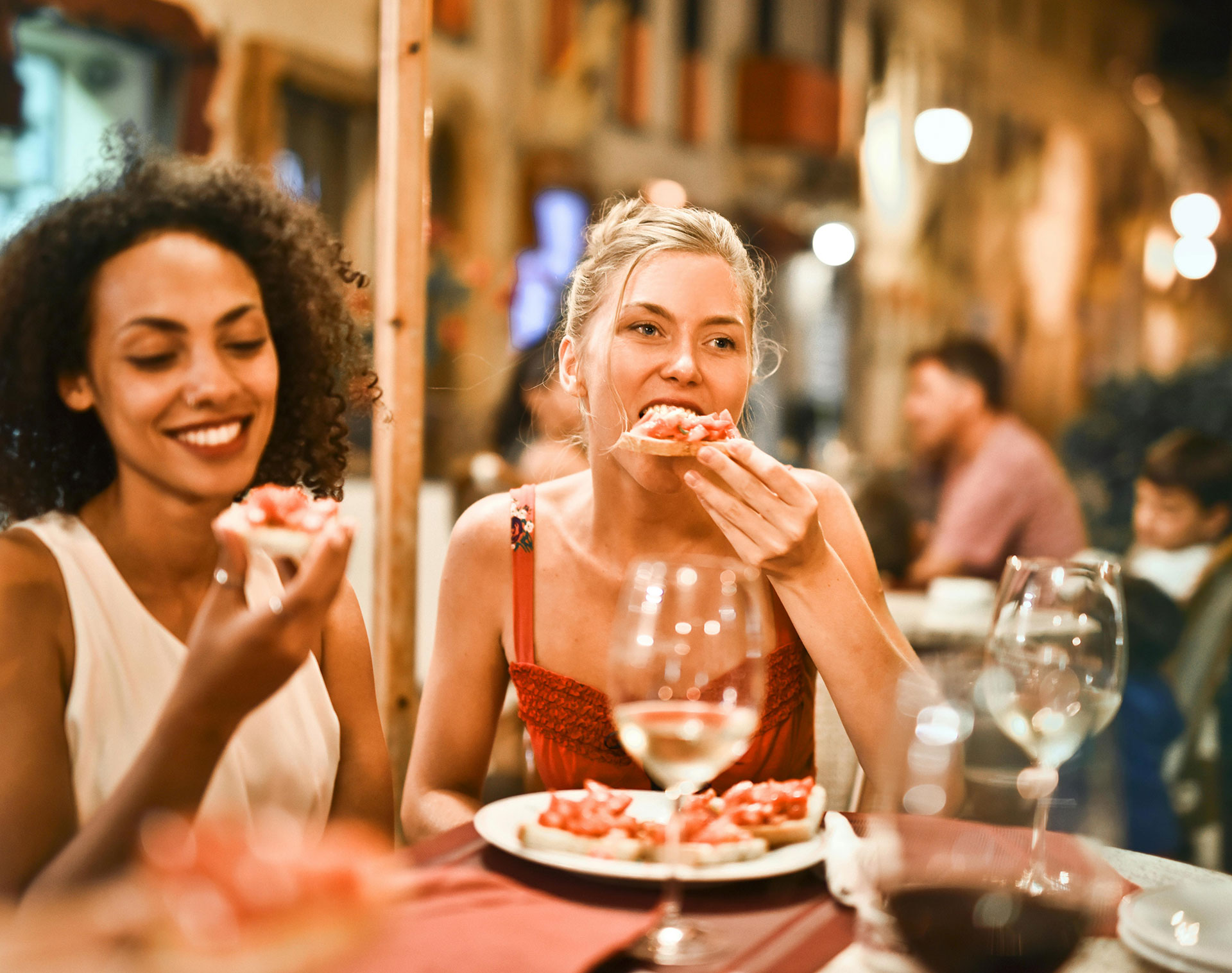 Two women eating pizza at restaurant