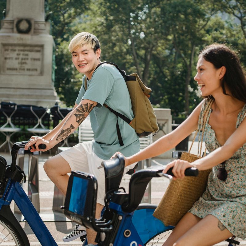 Two people smiling riding bikes