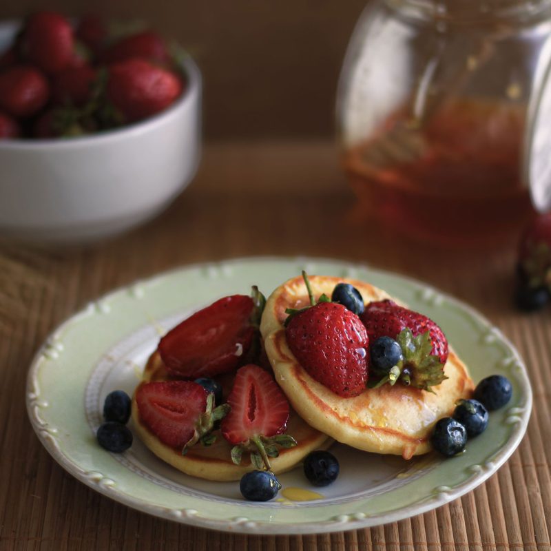 a plate of pancakes with berries on top